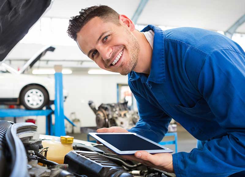 Technicians examining coolant levels and inspecting hoses in a service center